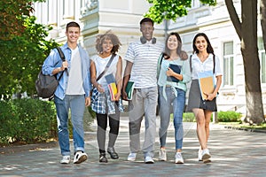 Happy College Friends Walking In Campus And Smiling To Camera