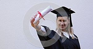 Happy college graduate showing her new graduation diploma