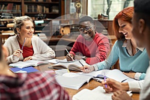 Happy college students studying together