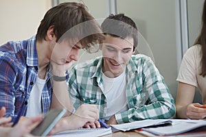 Happy college students talking in class