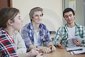 Happy college students talking in class