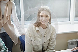 Happy college students talking in class