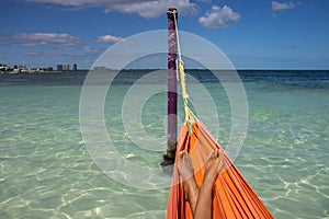 Happy and comfortable feet of a woman in a hammock happily enjoying the paradise of the caribbean sea