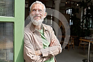 Happy confident european older man small business owner standing outside cafe.