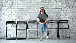 Happy confident female applicant looking at camera sit on chairs