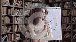 Happy confident hispanic young woman teacher looking away dreaming in classroom.