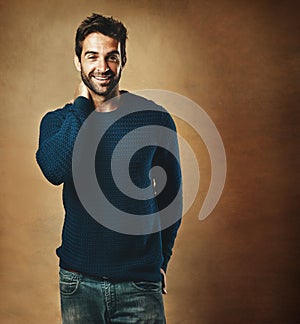 Happy and confident, thats him. Studio portrait of a handsome young man posing against a brown background.