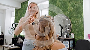 Happy confident young beautiful woman doing long hair style blonde.