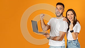 Happy confident young european man and woman winners in casual use laptop