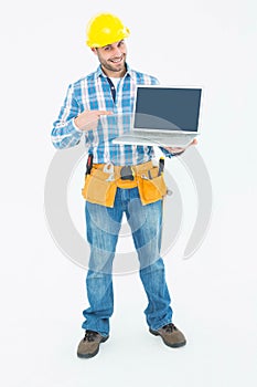 Happy construction worker pointing at laptop