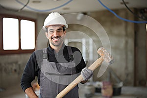 Happy construction worker posing in a house under renovation