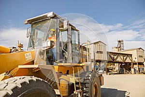 Manual worker driving cargo truck in plant