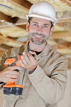 happy contractor employee holding hand power drill