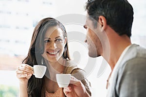 Happy, conversation and couple with coffee on date for romance or anniversary in cafeteria. Love, bonding and young man