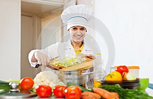 Happy cook works with vegetables