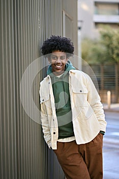 Happy cool gen z African American hipster guy standing at city street. Portrait