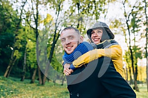 Happy Couple Having Fun in Autumn Park. Yellow Trees and Leaves. Laughing Man and Woman outdoor. Freedom Concept.