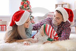 Happy couple with baby in Christmas hats