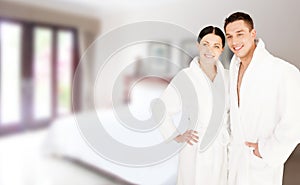 Happy couple in bathrobes over spa hotel room