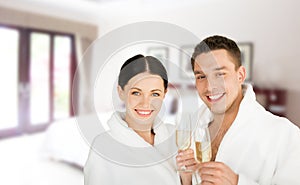 Happy couple in bathrobes over spa hotel room