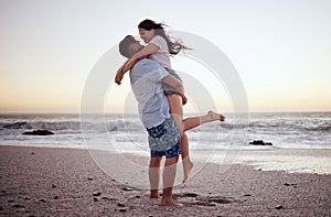 Happy couple at beach lift and hug to celebrate love on romantic sunset tropical ocean water Hawaii luxury vacation