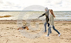 Happy couple with beagle dog on autumn beach