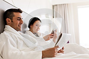 Happy couple in bed at home or hotel room