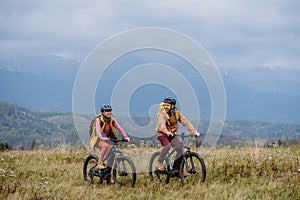 Happy couple at bicycles, in the middle of autumn nature. Concept of a healthy lifestyle.