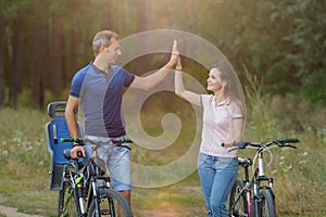 Happy couple with bikes funs in pine forest