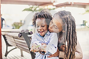 Happy couple black african skin people mother and son young together have fun and enjoy the outdoor leisure activity in the city