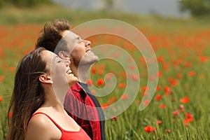 Happy couple breathing fresh air in a red field photo