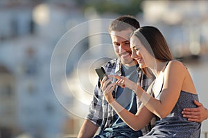 Happy couple browsing phone content in a town outskirts