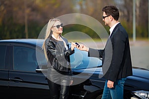 Happy couple buy new modern black car