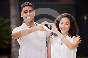 Happy couple buy real estate with key and heart hand sign and a smile together. Man and woman with keys or happiness