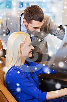 Happy couple buying car in auto show or salon