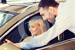 Happy couple buying car in auto show or salon