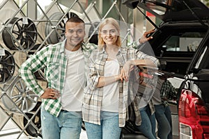 Happy couple buying new car together at the dealership