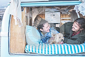 Happy couple camping during alternative vacation - Travel couple having fun together with their dog - Love, van lifestyle, surf