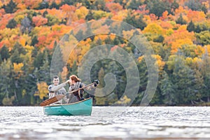 Happy couple canoeing in a lake in Canada