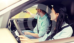 Happy couple in car taking selfie with smartphone