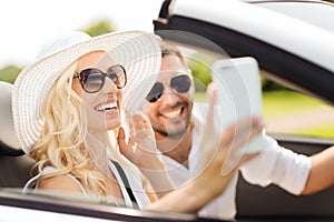 Happy couple in car taking selfie with smartphone