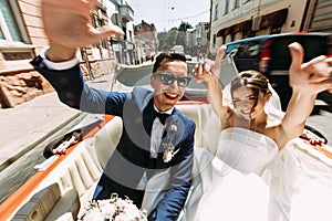 Happy couple in the car in the wedding day