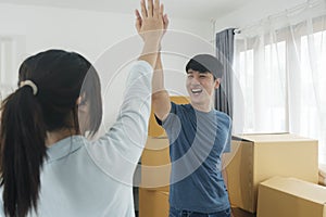 Happy couple with cardboard boxes in new house at moving day.