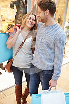 Happy Couple Carrying Bags In Shopping Mall