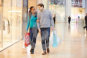 Happy Couple Carrying Bags In Shopping Mall