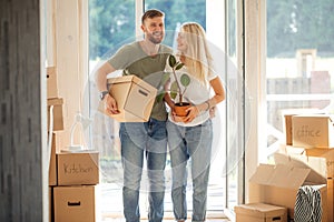 Happy Couple Carrying Cardboard Boxes Into New Home On Moving Day