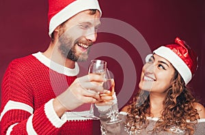 Happy couple celebrating Christmas holidays - Young people having fun drinking champagne and laughing during traditional event