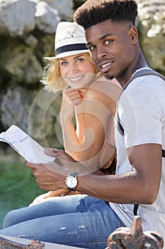 happy couple checking map outdoors photo