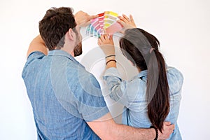 Happy couple choosing colors for decoration painting new house