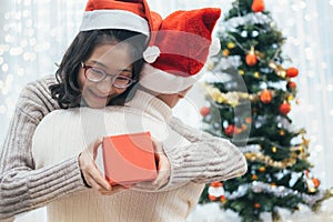 Happy couple with christmas present sitting and hugging